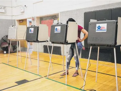  ?? PAT NABONG/SUN-TIMES ?? A person votes at Beulah Shoesmith Elementary School on the South Side during the Illinois primary on June 28.