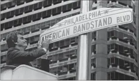  ?? THE ASSOCIATED PRESS ?? In this file photo, television personalit­y Dick Clark shines a new sign that changes a portion of Philadelph­ia’s Market Street to American Bandstand Boulevard, to recognize the 30th anniversar­y of the popular dance program that originated in...