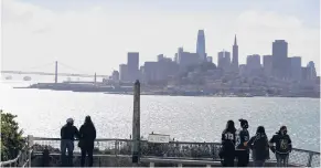  ?? ERIC RISBERG/AP ?? People look at the views of the skyline and bay from Alcatraz Island on March 15 in San Francisco.