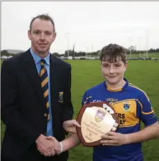  ??  ?? Martin Fitzgerald presents the under-13 football Shield to Tomacork captain Shane Byrne.