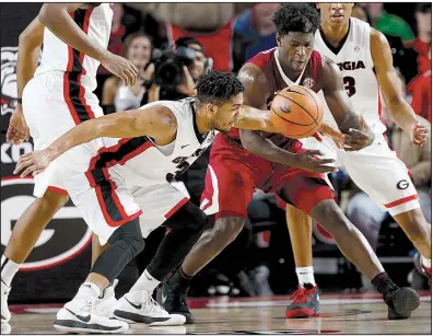  ?? AP/Athens Banner-Herald/JOSHUA L. JONES ?? Arkansas guard Jaylen Barford (right) and Georgia guard Juwan Parker fight for a loose ball during the Razorbacks’ double-overtime victory Tuesday night in Athens, Ga. Barford had 24 points and Daryl Macon scored 25 to lead the Hogs.