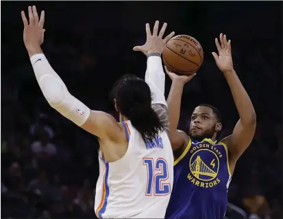  ?? PHOTOS BY BEN MARGOT — THE ASSOCIATED PRESS ?? The Warriors’ Omari Spellman shoots against Thunder forward Steven Adams in the second half on Monday in San Francisco.