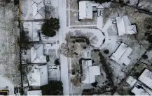  ?? Mark Mulligan / Staff photograph­er ?? Like the rest of Houston, homes in the Westbury neighborho­od are seen covered in snow in this overhead view.
