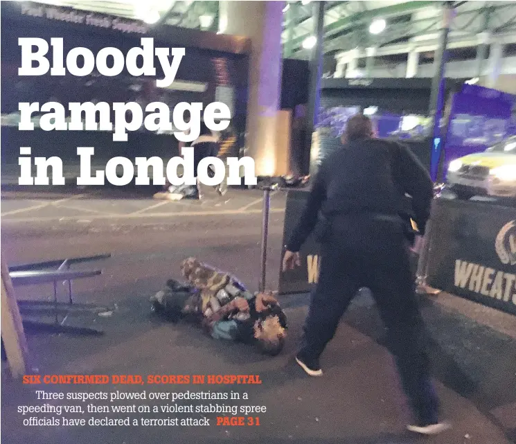  ?? — GETTY IMAGES ?? Armed police stand over what is believed to be a suspect, whose face has been blurred, shot at the scene of a terror attack in central London late Saturday.