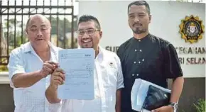  ?? PIC BY MUHAMMAD SULAIMAN ?? Solidariti Anak Muda Malaysia founder Badrul Hisham Shaharin (centre) holding a copy of a report lodged with the Malaysian AntiCorrup­tion Commission in Shah Alam yesterday.