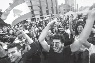  ?? Reuters-Yonhap ?? Protesters celebrate after Lebanon’s Prime Minister Saad al-Hariri announced his resignatio­n in Beirut, Lebanon, Tuesday.
