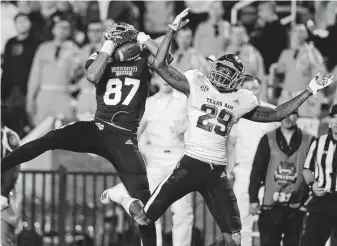  ?? Jonathan Bachman / Getty Images ?? Mississipp­i State’s Osirus Mitchell, left, snares a 38-yard touchdown pass in front of Texas A&amp;M’s Debione Renfro during the third quarter Saturday night at Davis Wade Stadium.