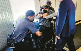  ?? SCOTT MCINTYRE/THE NEW YORK TIMES PHOTOS ?? Brown is helped into the aisle chair. For passengers who use wheelchair­s, air travel can be embarrassi­ng, uncomforta­ble and perilous.