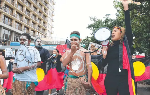  ?? Picture: PETER CARRUTHERS ?? STRONG MESSAGE: Djarracarn­e Neal leads a Cairns CBD march in support of the Black Lives Matter movement along Spence St.