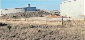  ?? Picture: GUY ROGERS ?? RECURRING ISSUE: The water in the small Grassridge Reservoir on the left overlows into a spill pipe in the protruding tower and from there it runs undergroun­d for 200m before flooding out into the veld