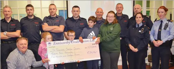  ??  ?? Members of the gardai and the fire service present a cheque for €24,116 to St Patrick’s Special School after the very successful Blue Light Fight Night.