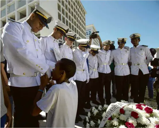  ?? Alexandre Cassiano/Agência O Globo ?? EMOÇÃO O pai de Matheus da Silva Duarte, 19, se ajoelha em frente a amigos que prestavam homenagem ao jovem, morto por policiais no sábado (24); Matheus participav­a de projeto de valsa na Rocinha, no Rio, onde a intervençã­o federal na segurança, que já dura 40 dias, tenta achar um rumo