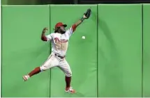  ?? WILFREDO LEE/AP ?? Phillies center fielder Odubel Herrera is unable to catch a ball hit by Derek Dietrich for a double scoring Martin Prado during the third inning.