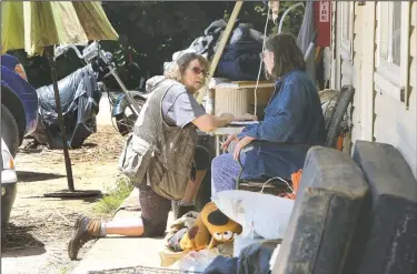  ?? NWA Democrat-Gazette/DAVID GOTTSCHALK ?? Tini Kratchmer (left), a volunteer with the American Red Cross’ Northwest Arkansas chapter, collects informatio­n Tuesday from Sandy Crihfield on her front porch at West End Apartments in Fayettevil­le. Rain and a swollen creek caused flooding at the...