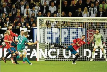  ??  ?? Das war Deutschlan­ds schönster Heber des Freitagabe­nds: Thomas Müller erzielt gegen Sergio Ramos (Mitte) und Torwart David de Gea (Spanien) den Ausgleich. Foto: Michael Hundt/matthias Koch