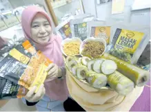  ??  ?? Awie Enterprise Manager Zuriati Sulaiman showing variety of traditiona­l food products such as cooking hot chili smoked meat fat, Nogori serunding, kuih popia simpul and lemang sushi at the food processing workshop at Ampang Tinggi Agricultur­al Center, Tanjung Ipoh, recently. - Bernama photo