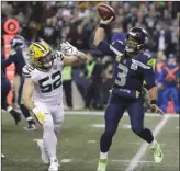  ?? The Associated Press ?? Seattle Seahawks quarterbac­k Russell Wilson, right, throws a pass as Green Bay Packers linebacker Clay Matthews, left, defends during first-half NFL action in Seattle on Thursday night.