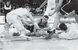  ?? Adam Hunger / Associated Press ?? In a game where smooth plays were not the norm, Texas Tech guard Kevin McCullar, center, scrapes for a loose ball with two Tennessee players.