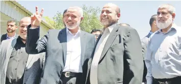  ??  ?? Hamas Prime Minister in the Gaza Strip Ismail Haniya Hamas (left) flashes the V-sign for victory as he greets deputy leader Musa Abu Marzuk (second right) upon his arrival in Gaza City. — AFP photo
