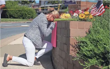  ?? MARK WILSON/ GETTY IMAGES ?? Lynne Griffin pays her respects on Thursday. One of the victims was her journalism teacher.