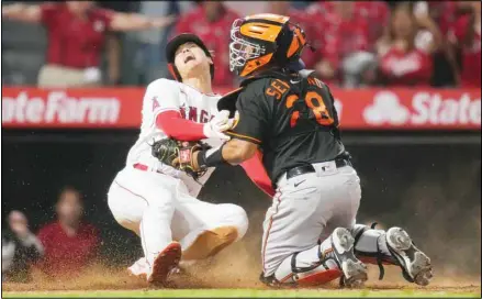  ??  ?? Los Angeles Angels designated hitter Shohei Ohtani (17) slides in to home to score ahead of a tag by Baltimore Orioles catcher Pedro Severino (28) during the ninth inning of a baseball game, on July 2, in Anaheim, California. (AP)