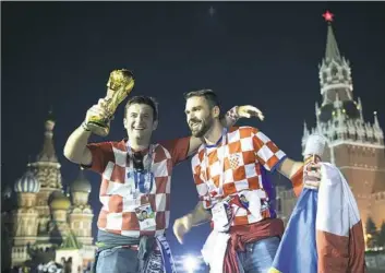  ?? Alexander Zemlianich­enko/Associated Press ?? Croatia soccer fans celebrate with a model of the World Cup trophy in Moscow’s Red Square after their team beat England in Wednesday’s semifinal match.