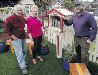  ?? ADRIAN LAM, TIMES COLONIST ?? Teale Phelps Bondaroff, right, stands with builder and homeowner Jim Pungente and his wife Inga by Moss Rocks Little Library, which has two reading benches and solar-powered lights to help people peruse its collection.