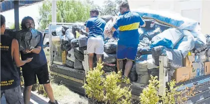  ?? SILVIO JAVIER GIL ?? Colaboraci­ón. Gente de la peña Roberto Mouzo descarga las bolsas traídas desde el club.