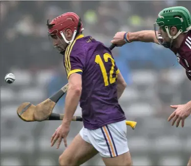  ??  ?? Barry Carton on the move as Galway captain David Burke closes in during Sunday’s epic league encounter in Pear