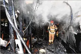  ?? KYUNGNAM SHINMUN VIA GETTY IMAGES ?? A firefighte­r inspects the damage caused by a fire that killed 37 people in a hospital in Miryang, South Korea, on Friday. Many of the victims were elderly. An official said the hospital did not have a sprinkler system.