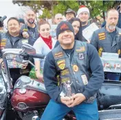  ??  ?? Marty Gagne holds the Nambé angel he was presented with this week for being an Angels Among Us recipient. Gagne, a member of the Onagers motorcycle club, organizes the Duke City Toy Run.