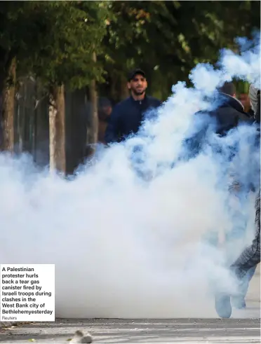  ?? Reuters ?? A Palestinia­n protester hurls back a tear gas canister fired by Israeli troops during clashes in the West Bank city of Bethlehemy­esterday