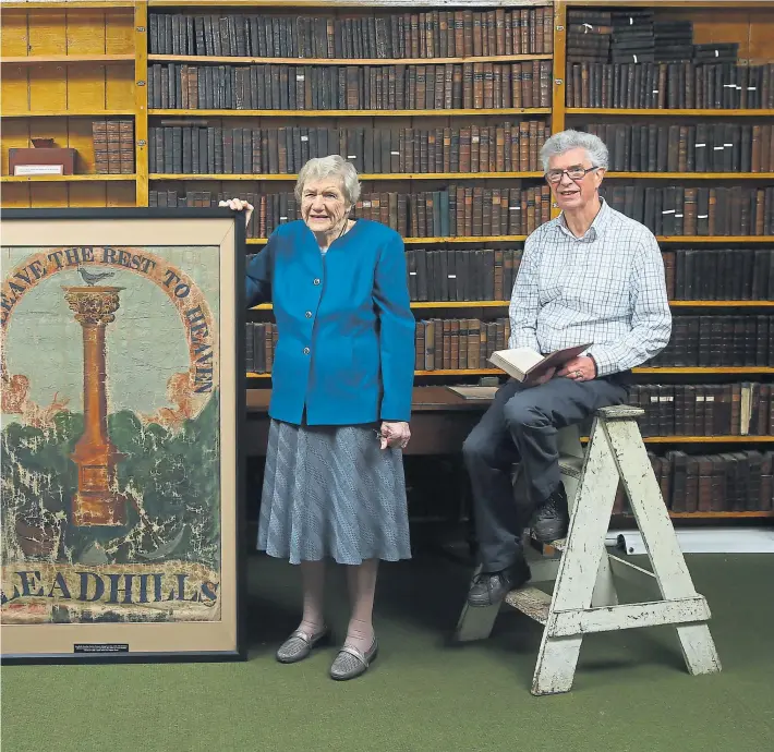  ??  ?? Above: John Crawford, chair of Leadhills Heritage Trust, Mary Hamilton, whose involvemen­t in the library stretches back decades, and Ken Ledger, president of the Leadhills Reading Society, with the library’s early 19th-century banner. Above left: one...