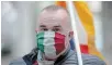  ?? THE ASSOCIATED PRESS ?? A man wears a face mask in the colours of the Italian flag during a protest against government restrictio­n measures to curb the spread of COVID-19.
