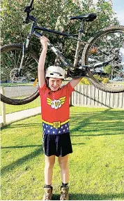  ??  ?? Noah Gilbertson holds his bike aloft after completing his goal of riding 800km during the month of October, raising over $20,000 for children’s cancer.