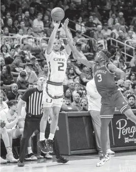  ?? D.A. VARELA dvarela@miamiheral­d.com ?? Hurricanes guard Isaiah Wong, who scored 21 points, shoots a three-pointer over Cardinals guard El Ellis during the second half of Miami’s 93-85 victory on Saturday night.