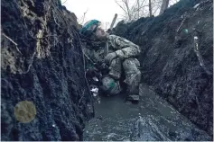  ?? The Associated Press ?? A Ukrainian soldier takes cover in a trench under Russian shelling on the frontline close to Bakhmut, Donetsk region, Ukraine, on Sunday.