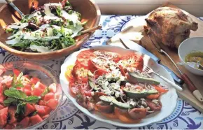  ?? ANGELA PETERSON/MILWAUKEE JOURNAL SENTINEL ?? Heirloom tomato salad with feta (center), watermelon salad with mint and lime, and arugula, radicchio and Parmesan salad, along with rotisserie chicken, add up to a cool summer meal.