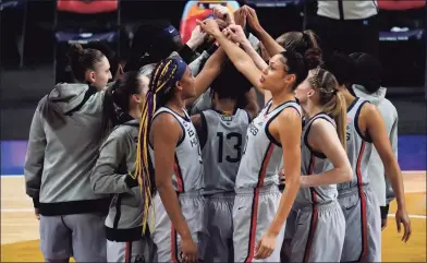  ?? Eric Gay / Associated Press ?? Above, UConn players huddle before Friday’s women’s Final Four NCAA college basketball semifinal game against Arizona.