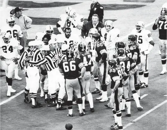  ?? HALL OF FAME VIA AP ?? Officials review a TD by the Steelers’ Franco Harris in an AFC playoff game on Dec. 23, 1972. The NFL’s supervisor of officials, Art McNally, was consulted in the press box.