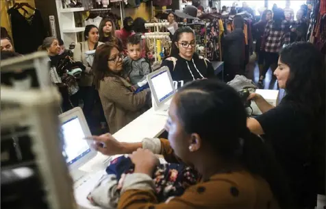  ?? Chieko Hara/The Portervill­e Recorder via AP ?? Black Friday shoppers fill a store in Portervill­e, Calif., in November. Some companies that have flexibilit­y at holiday time give staffers an afternoon of their choosing off. Employees will consider that time to be a real gift, and knowing they’ll have a little free time may help them stay focused the rest of the holiday season.