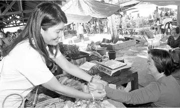  ??  ?? #AnakAnakMa­laysia wristbands being distribute­d to the public at Donggongon market in the run-up to Malaysia Day celebratio­ns.