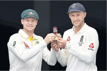  ?? AFP ?? Australia captain Steve Smith, left, and England captain Joe Root pose with the Ashes Urn at the Gabba in Brisbane.