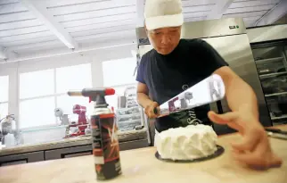  ??  ?? Sky Yang cuts a red velvet chiffon cake (inset) Tuesday at B&amp;B Bakery. Yang’s chiffon cakes are all gluten-free, jewel-like sculptures made with a mixture of almond and rice flour.