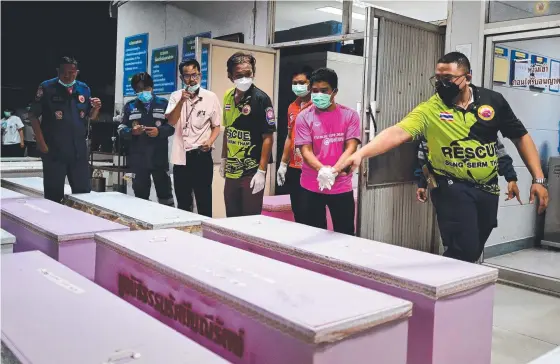  ?? Picture: AFP ?? Rescue personnel count coffins carrying the bodies of victims at a hospital morgue in Udon Thani after the mass killings.