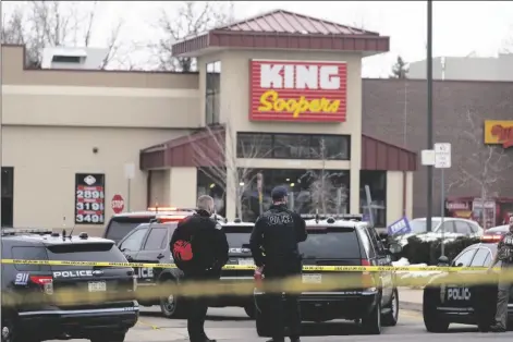  ?? DAVID ZALUBOWSKI/AP ?? POLICE STAND OUTSIDE A KING SOOPERS GROCERY STORE where a shooting took place Monday in Boulder, Colo.