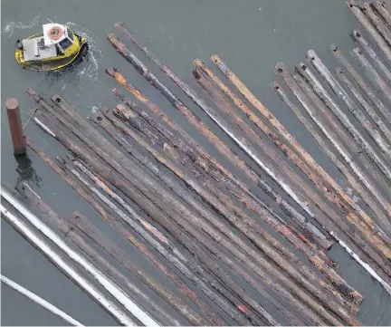  ?? DARRYL DYCK/THE CANADIAN PRESS ?? A worker in a boat moves logs on the Fraser River in Delta, B.C. Forestry firms across Canada fear thousands of sawmill jobs are threatened if the U.S. slaps duties on softwood, which one analyst predicted could be a “shock and awe” level of 30 to 40...