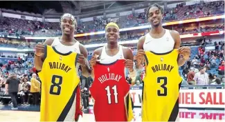  ?? FE ?? Los hermanos Jrue (izq.), Aaron y Justin tras intercambi­ar camisetas.