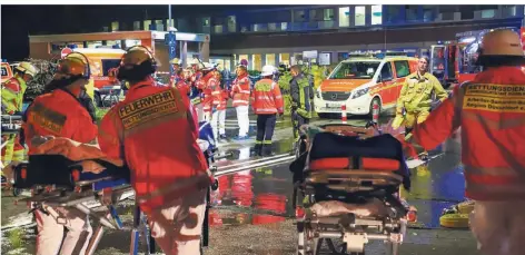  ?? FOTO: DPA ?? Feuerwehrl­eute mit Krankentra­gen stehen nach einem Brand im Düsseldorf­er Marienhosp­ital vor dem Krankenhau­s, um Patienten zu versorgen.