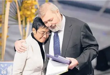  ?? ALEXANDER ZEMLIANICH­ENKO/AP ?? Fighting for freedom: Nobel Peace Prize winners Dmitry Muratov from Russia, right, and Maria Ressa of the Philippine­s, embrace Friday during the Nobel Peace Prize ceremony at Oslo City Hall, Norway. The Norwegian Nobel Committee cited Ressa and Muratov’s fight for freedom of expression, stressing that it is vital in promoting peace.